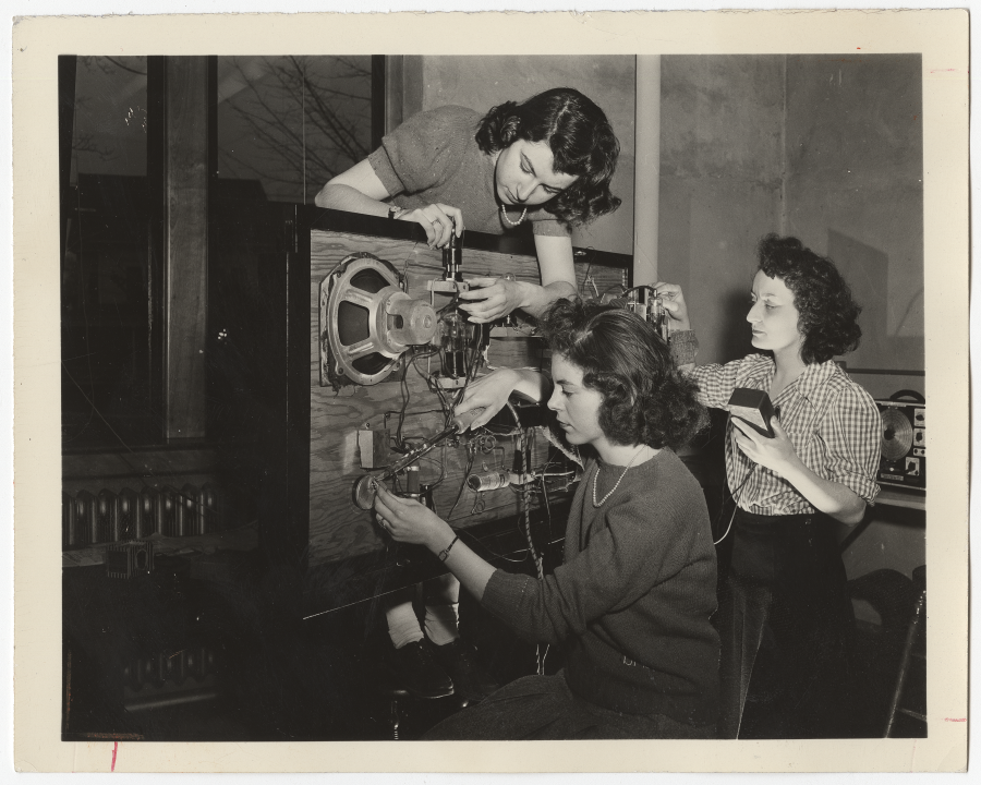Three students using radio equipment.