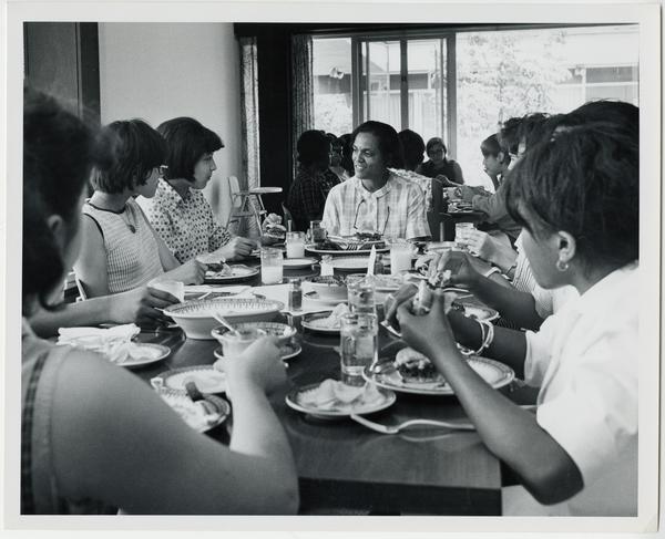 A group of young Black women sit at a dining table with Frances Kerr.