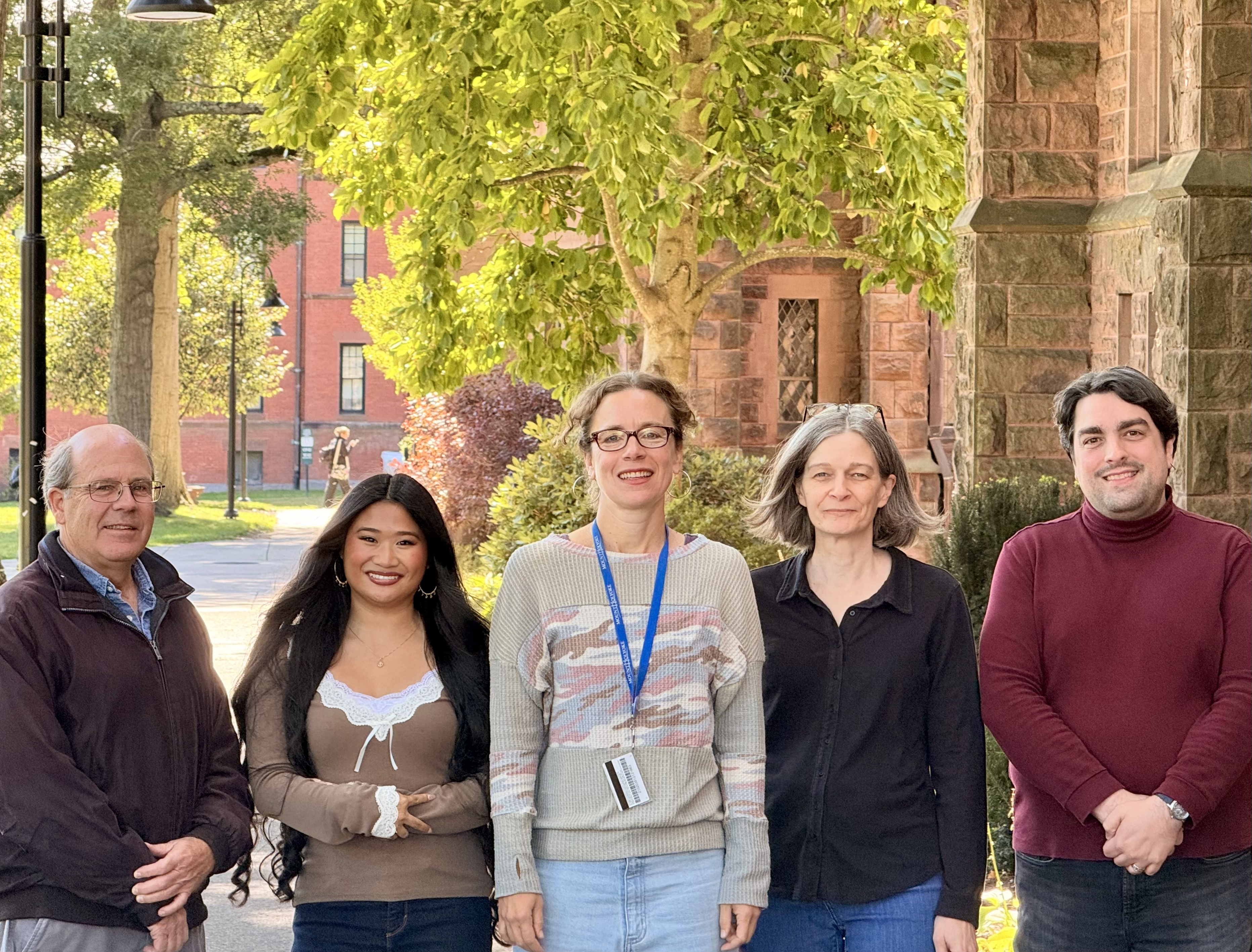 A picture of the Mount Holyoke Research Services staff standing on the path in front of the library. In order: Jim Burke, Brandi Hart, Irene McGarrity, Mary Stettner, and Amedeo DeCara